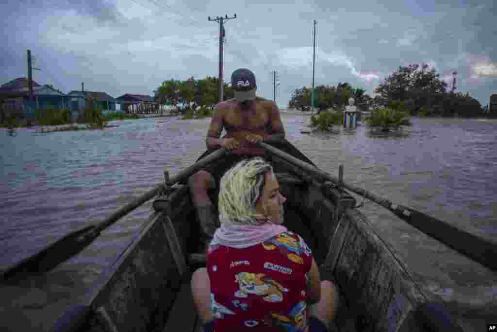 Cubanos&nbsp;recorren una calle inundada en un bote de madera en Guanimar, provincia de Artemisa, donde varias localidades quedaron bajo el agua tras el pasod el huracán Helene, el miércoles 25 de septiembre de 2024. (Foto AP/Ramon Espinosa)