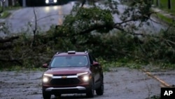 Vehículos entre árboles caídos tras el paso del huracán Helene, el viernes 27 de septiembre de 2024, en Valdosta, Georgia. (Foto AP/Mike Stewart)